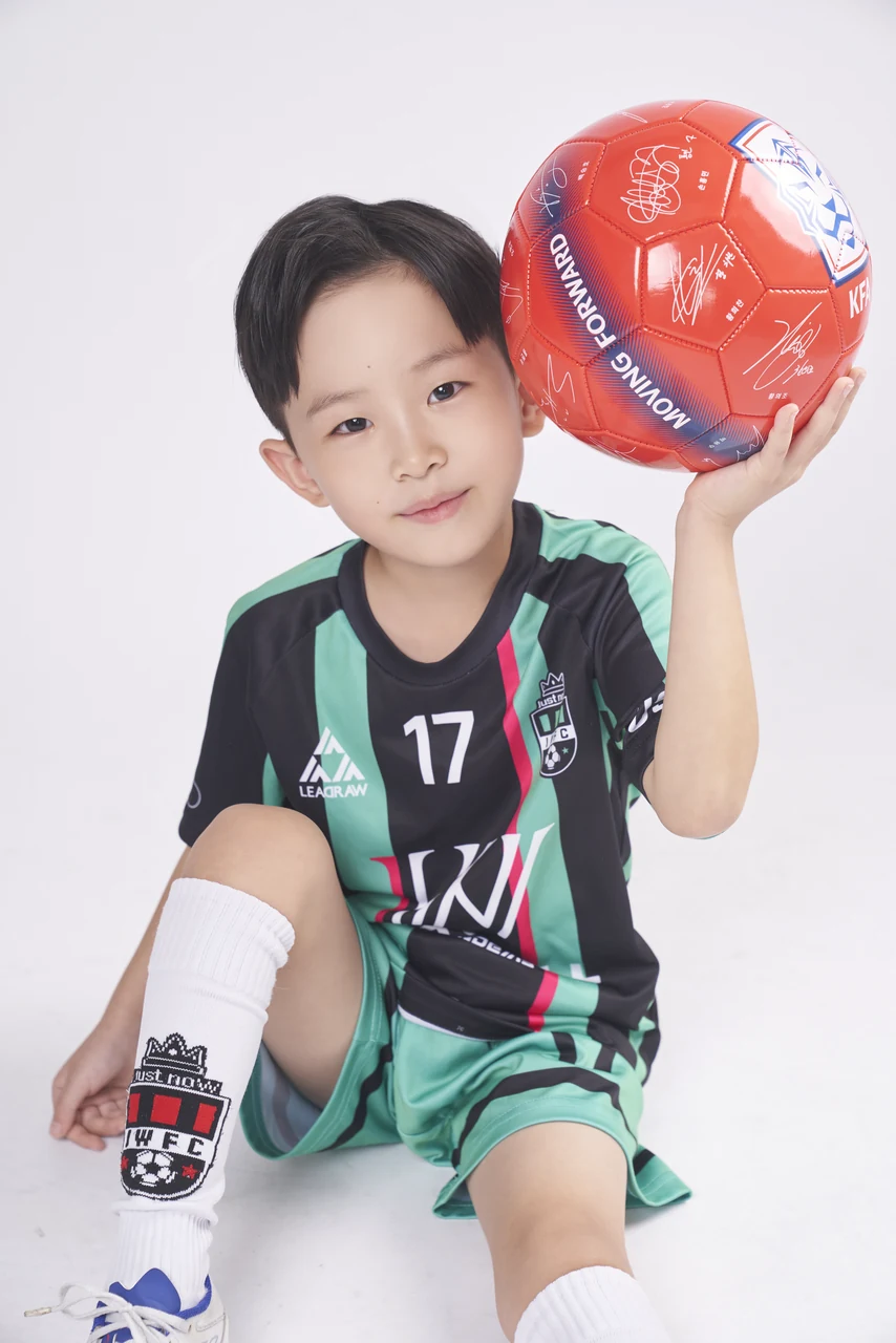 유니폼과 축구공으로 활기를 담은 어린이 사진
